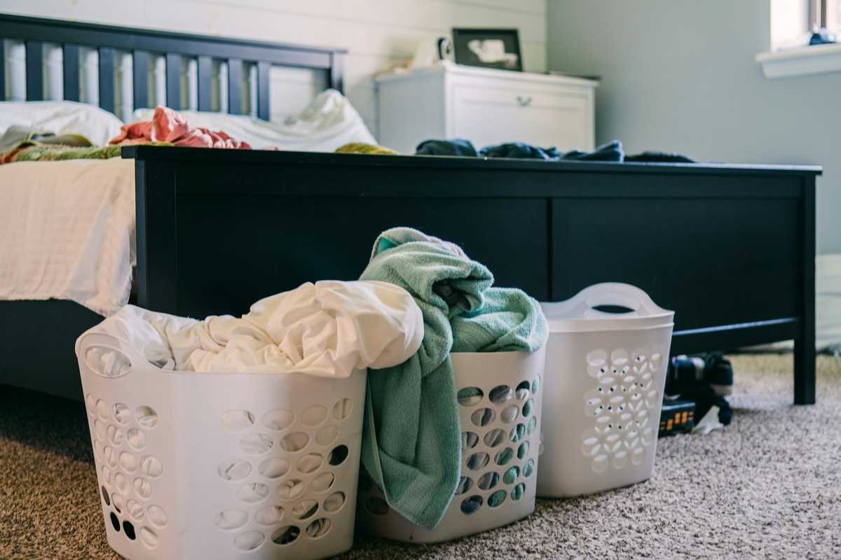 Three laundry baskets on a bedroom floor, waiting to be washed