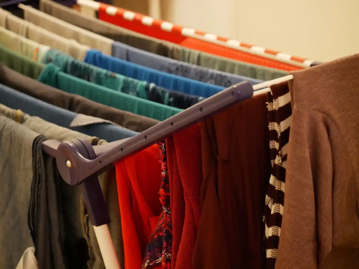 Colourful clothes and towels hanging on an indoor drying rack